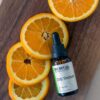 CBD oil tincture next to sliced oranges